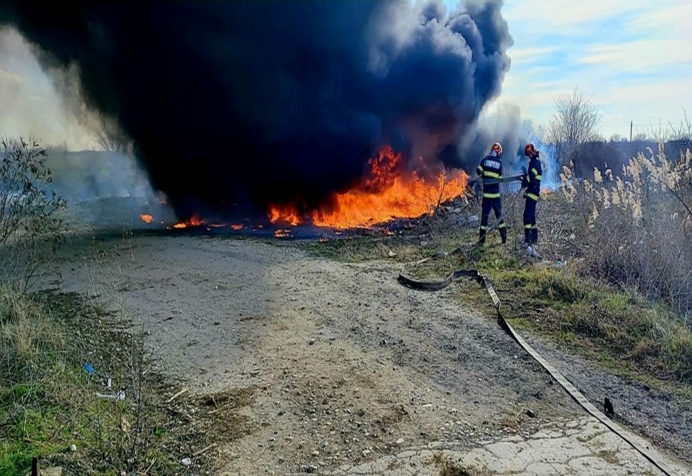 Incendiu violent cu degajări mari de fum pe un teren din Crivina. Au ars anvelope şi vegetaţie uscată